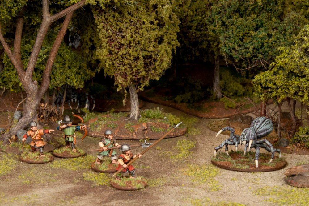 Halflings take on a miniature spider in this skirmish game setting