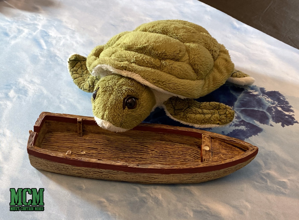 A Plush Turtle toy finds a boat in a frozen lake.