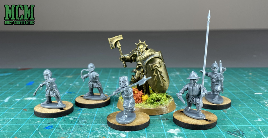 A Stormcast Enteral alongside a bunch of halflings